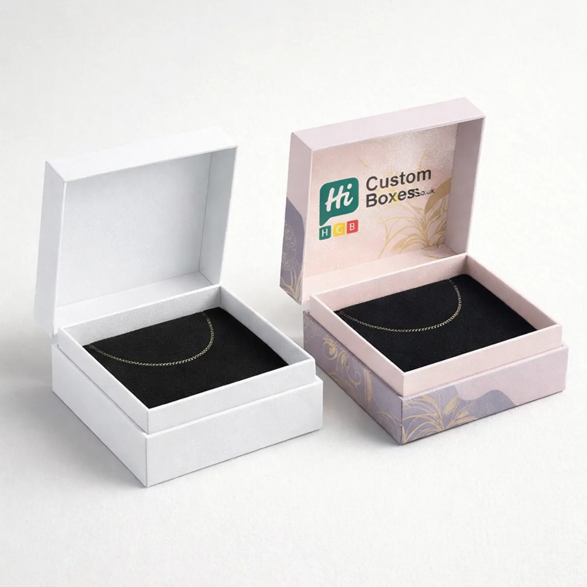 Square luxury gift boxes with matching lids and bases- showcasing gold anklets against dark velvet- class=